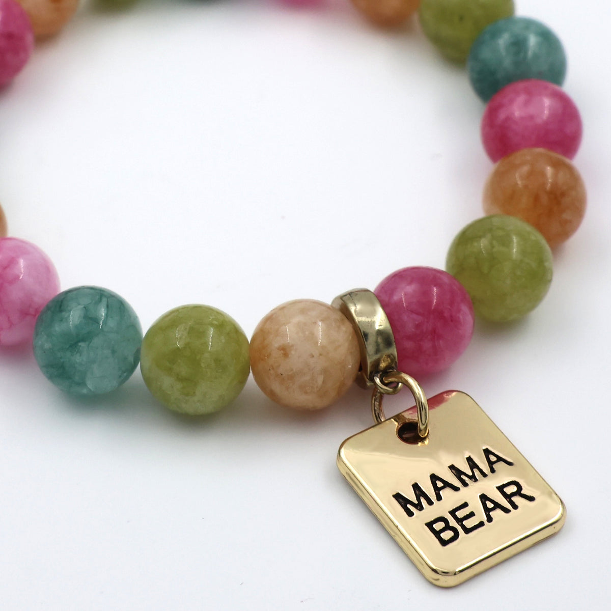 Multicolored beaded bracelet with a gold 'MAMA BEAR' charm on a white background