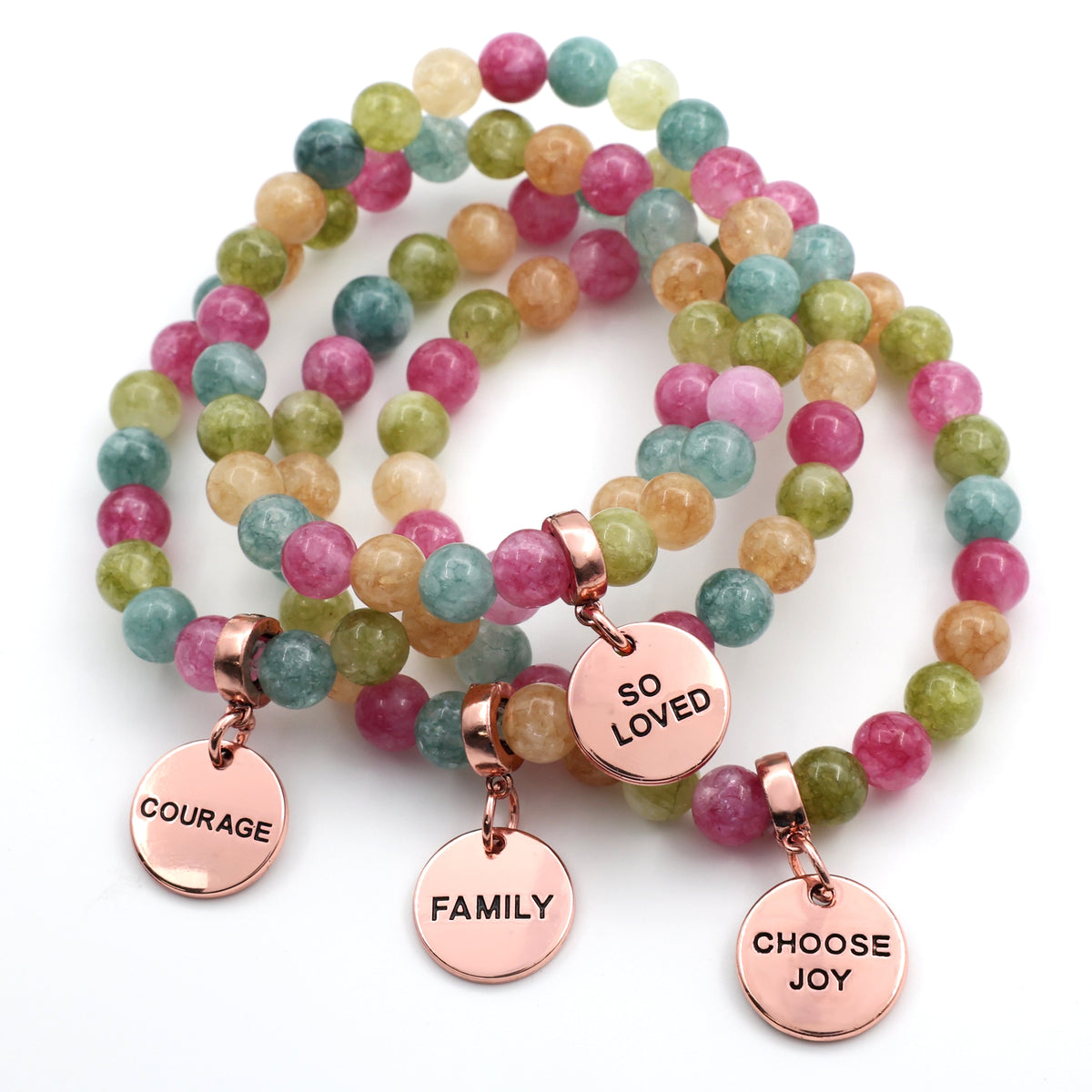 Multicolored beaded bracelets with rose gold charms on a white background