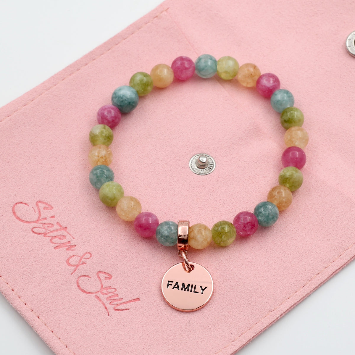 Multicolored beaded bracelet with a 'FAMILY' charm on a pink card