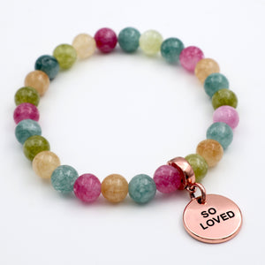 Multicolored beaded bracelet with a 'SO LOVED' charm on a white background