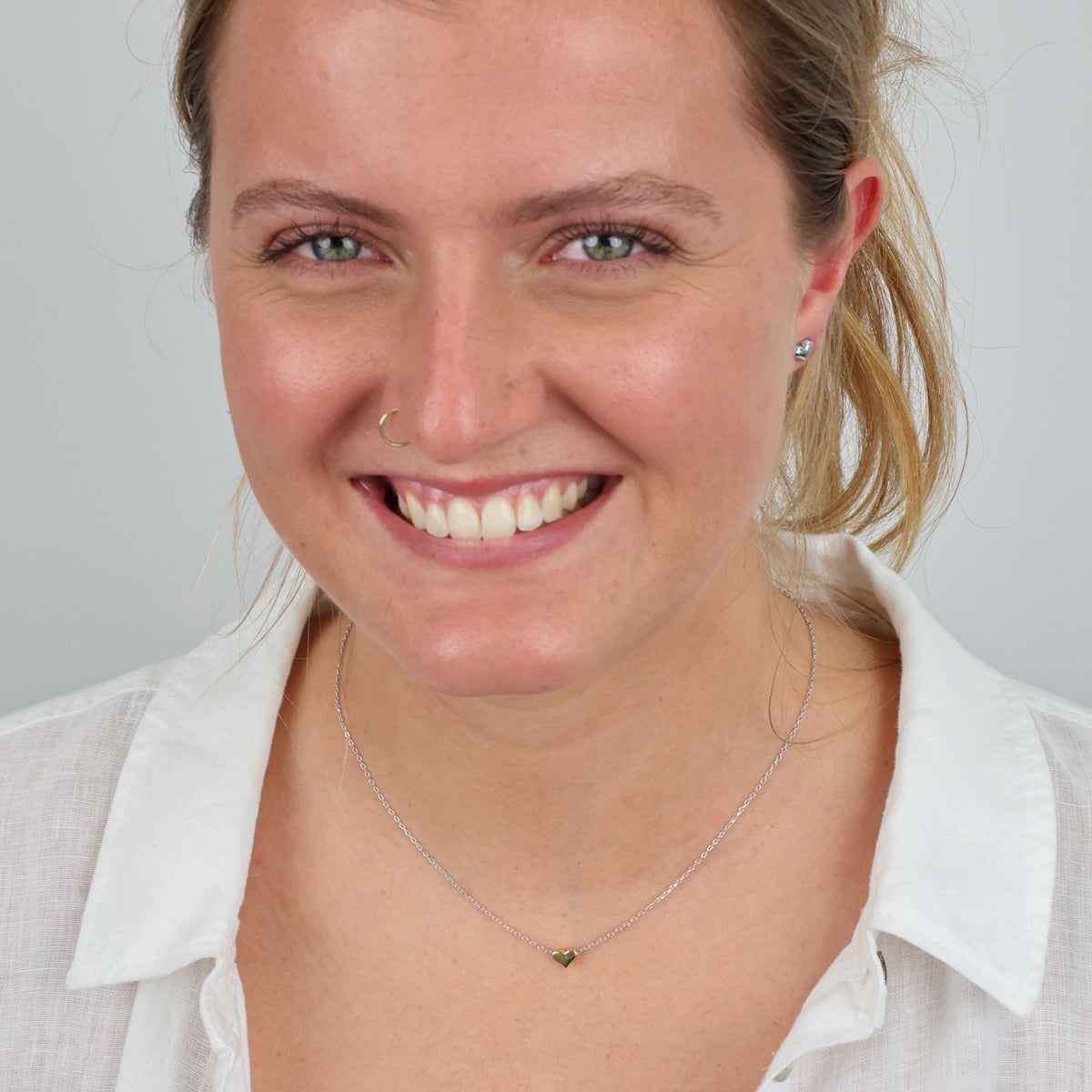 Woman wearing a white shirt with a plain background