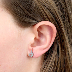 Close-up of a gymnastics ear wearing a unique silver earring.