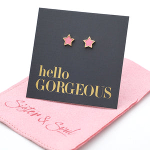 Pink star shaped studs presented on a grey card with gold 'Hello Gorgeous' writing sitting on a pink pouch with 'Sister & Soul' writing.