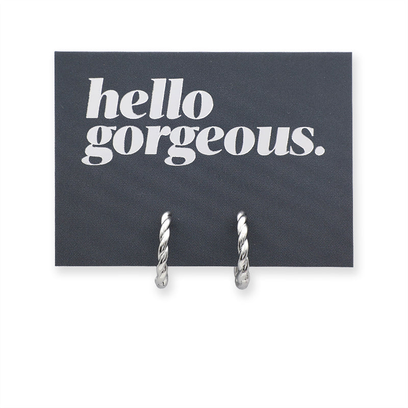 Silver twisty hoops on a grey card that has silver writing saying "Hello Gorgeous" on a white background