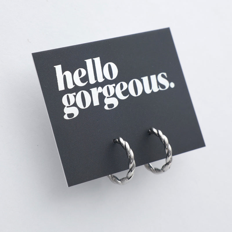 Silver twisty hoops on a grey card that has silver writing saying "Hello Gorgeous" on a white background