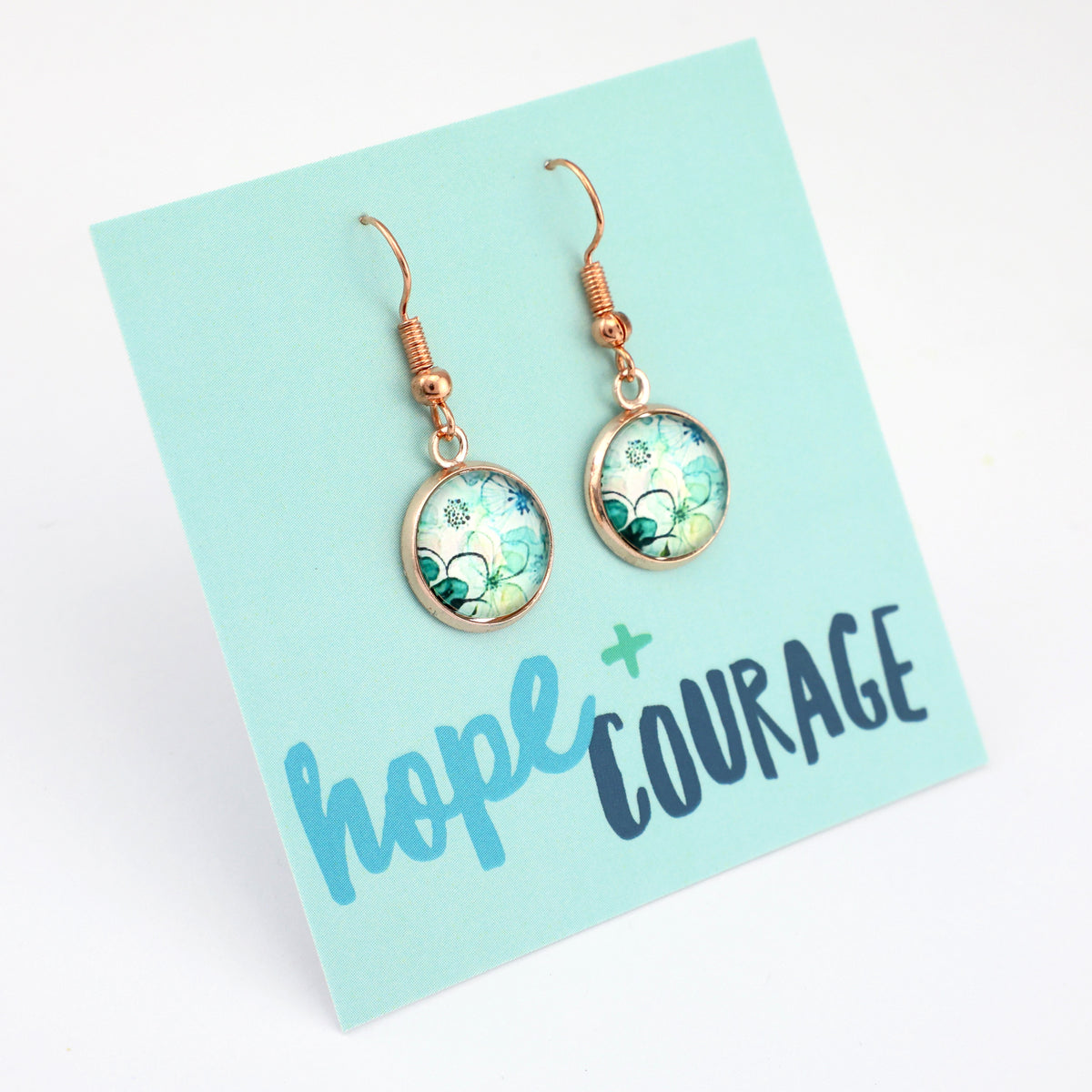 Pair of earrings on a card with 'hope + courage' text