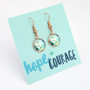 Pair of earrings on a card with 'hope + courage' text