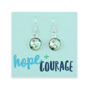 Earrings on a card with 'hope + courage' text