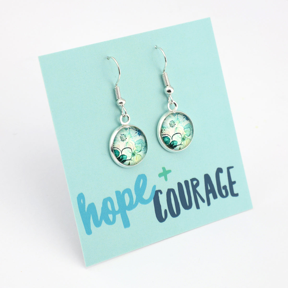 Earrings on a card with 'hope + courage' text