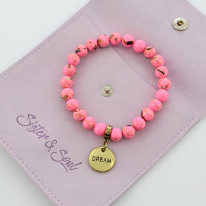 pink bracelet on gift ouch with word charm - dream
