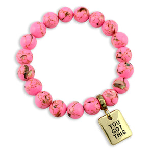 Pink beaded bracelet with a gold tag saying 'You Got This' on a white background