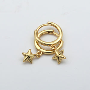 Gold hoop earrings with star charms on a light gray background