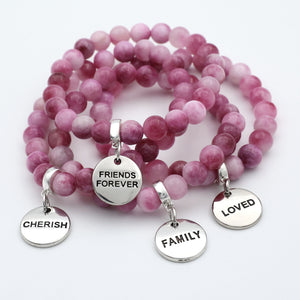 Pink beaded bracelets with silver charms on a white background
