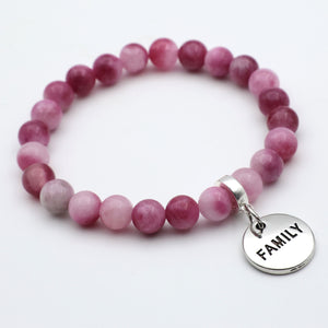 Pink beaded bracelet with a 'FAMILY' charm on a white background