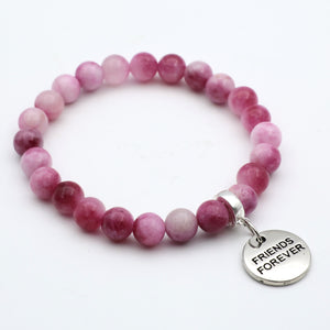 Pink beaded bracelet with a 'Friends Forever' charm on a white background