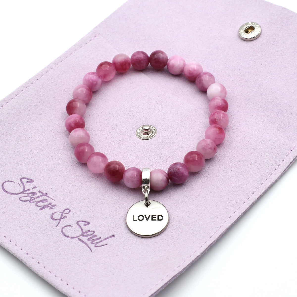 Pink beaded bracelet with 'LOVED' charm on a pink card with 'Sister & Soul' branding.