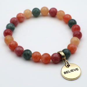 Multicolored beaded bracelet with a gold 'BELIEVE' charm on a white background