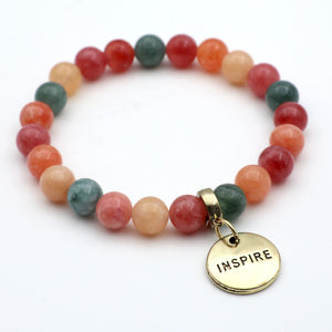Multicolored beaded bracelet with a gold 'INSPIRE' charm on a white background