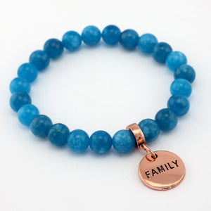 Blue beaded bracelet with a rose gold 'FAMILY' charm on a white background
