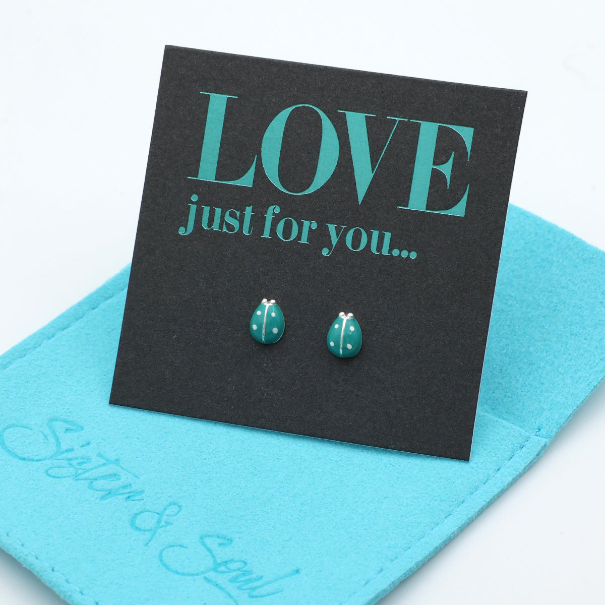 Teal earrings on a black card with 'LOVE just for you' text, on a blue background