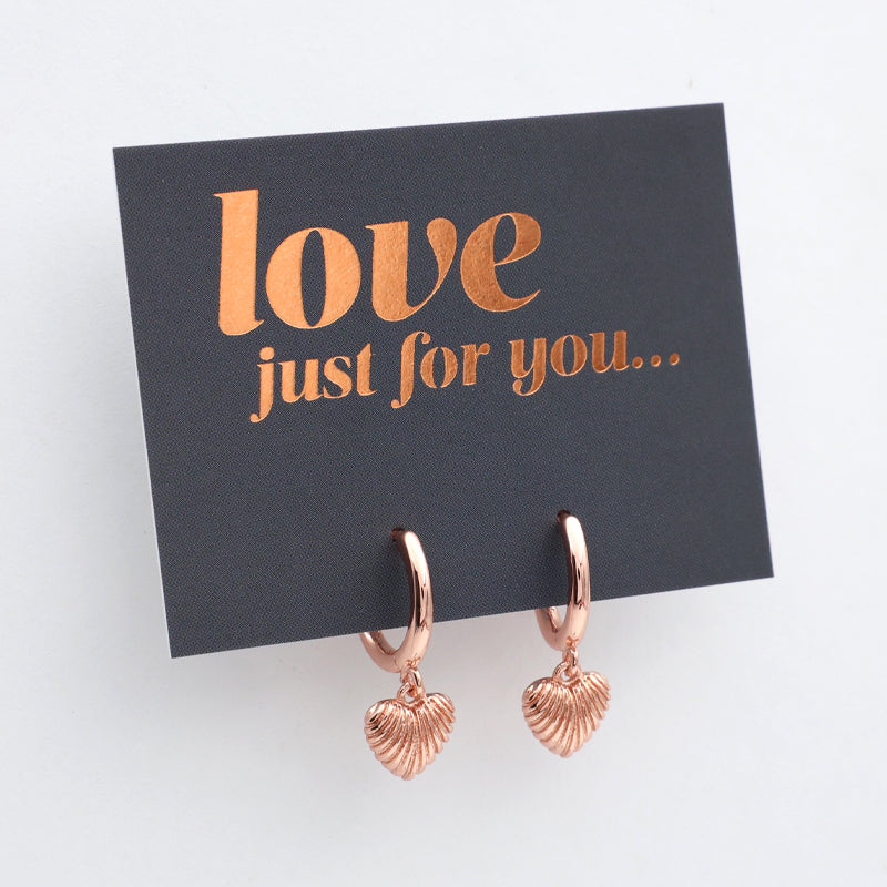 Rose gold heart-shaped earrings on a black card with 'love just for you' text.