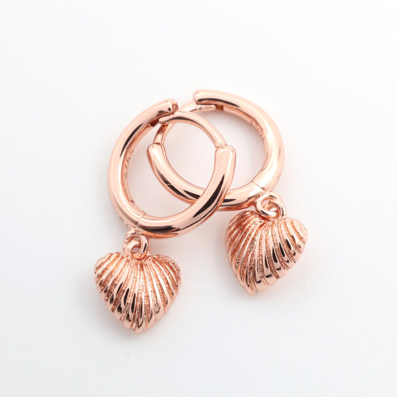 Rose gold hoop earrings with shell charms on a white background