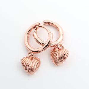 Rose gold hoop earrings with shell charms on a white background