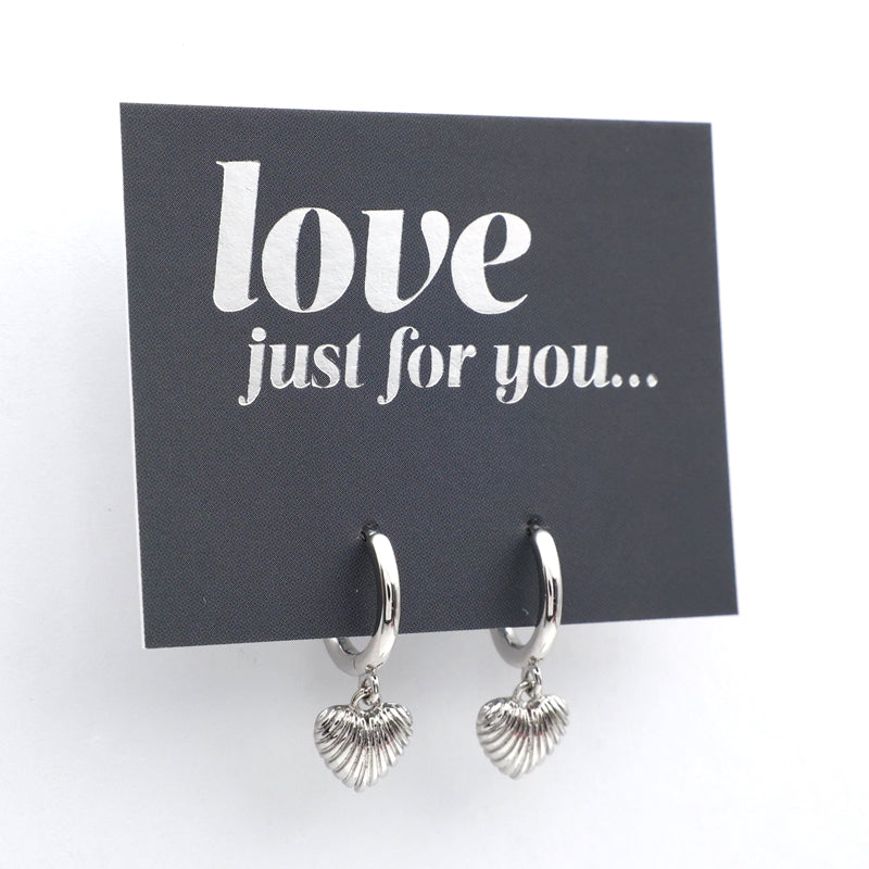 Silver hoop earrings with heart charms on a 'love just for you' card.