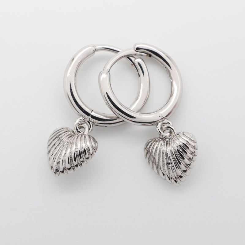 Silver hoop earrings with shell charms on a light gray background