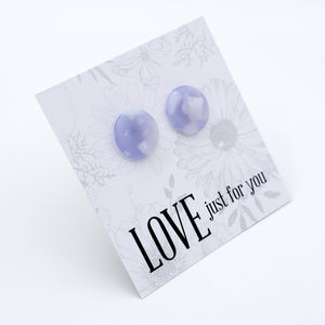 A pair of round, lavender-colored stud earrings mounted on a white floral display card with the text 'LOVE just for you' printed in black. The card is photographed at an angle against a clean white background.
