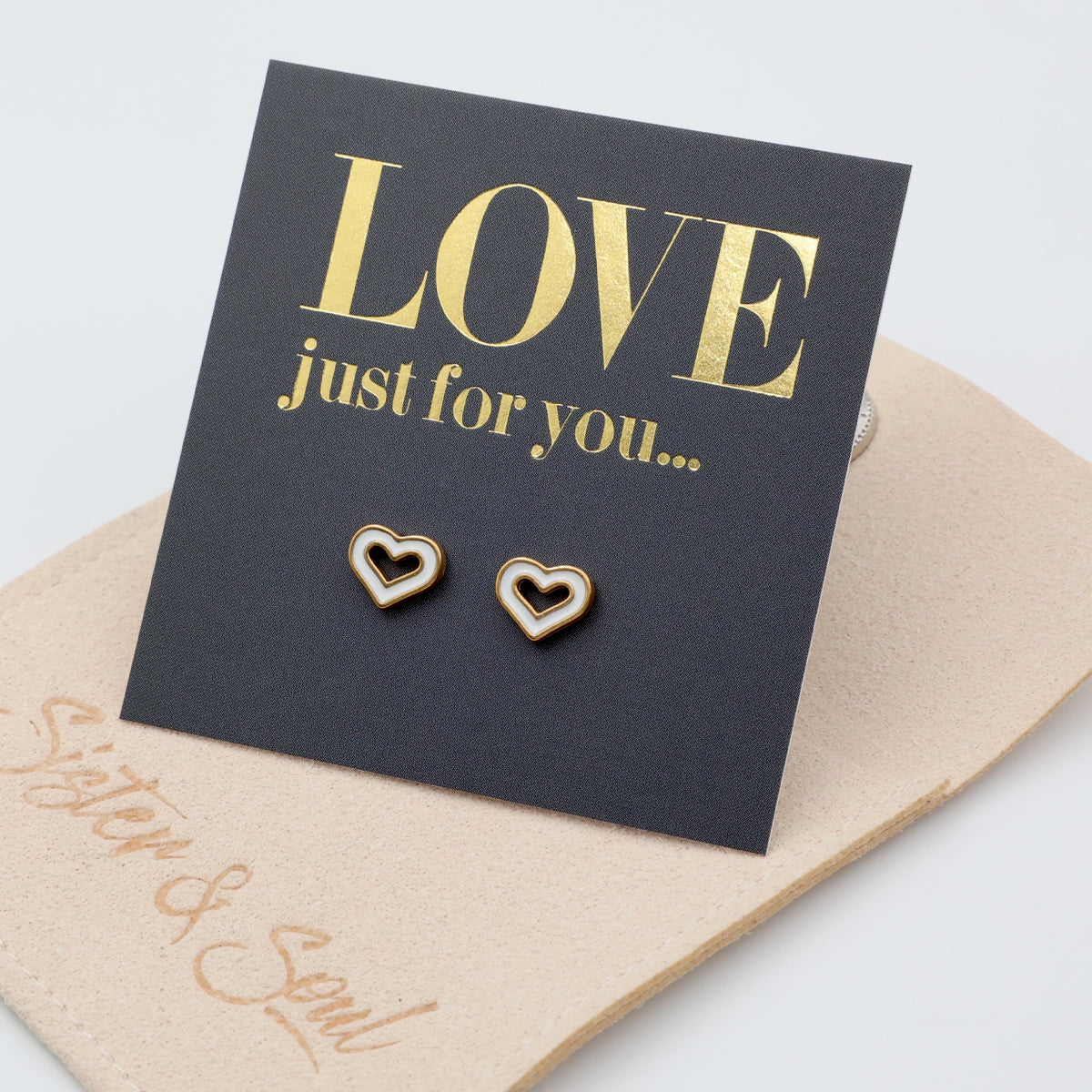 Heart-shaped earrings on a 'LOVE just for you' card with beige envelope