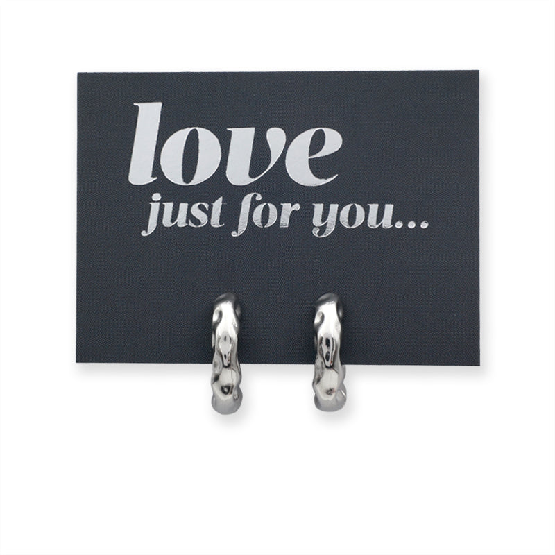 Silver Huggies hoop earrings on a grey card with silver wording that says "love just for you" on a white background