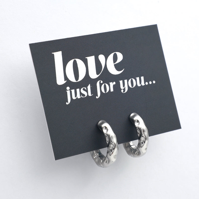 Silver Huggies hoop earrings on a grey card with silver wording that says "love just for you" on a white background
