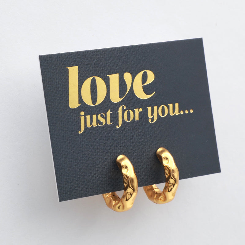 Gold hoop earrings on a love just for you card 