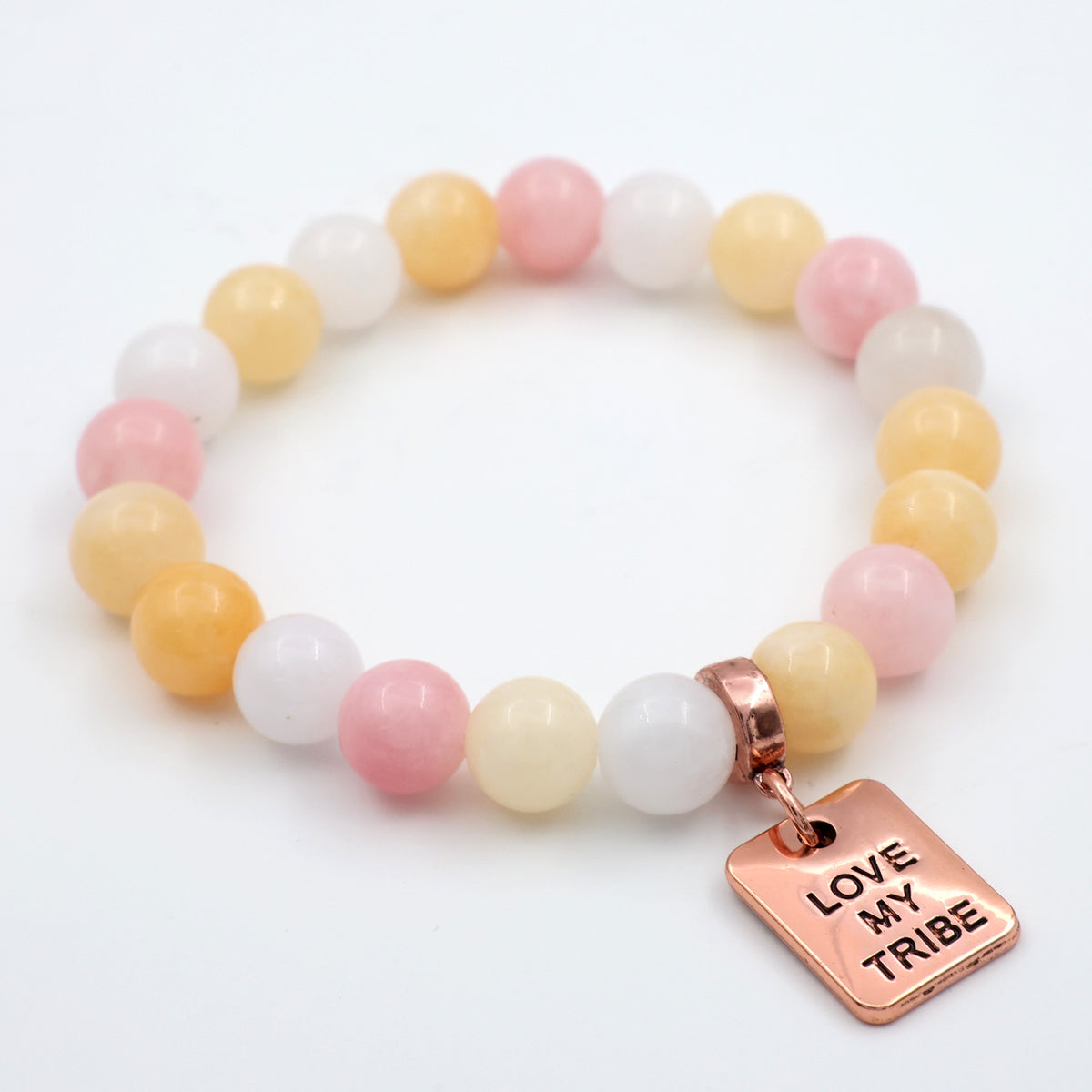 Bracelet with pastel beads and a rose gold 'Love My Tribe' charm on a white background