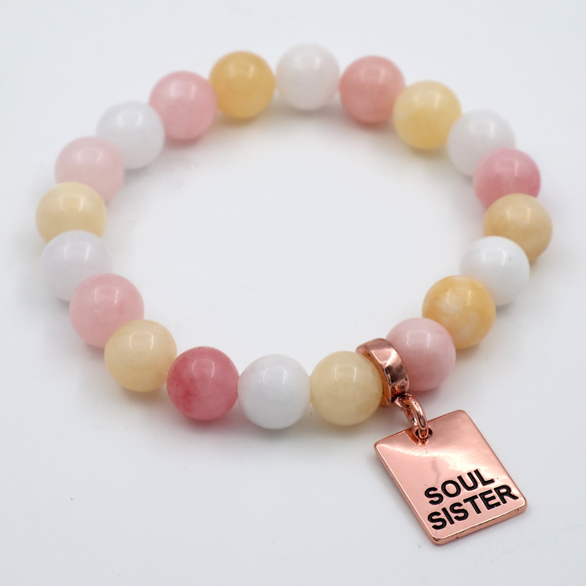 Multicolored beaded bracelet with a 'Soul Sister' charm on a white background