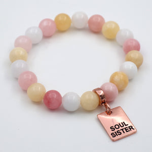 Multicolored beaded bracelet with a 'Soul Sister' charm on a white background