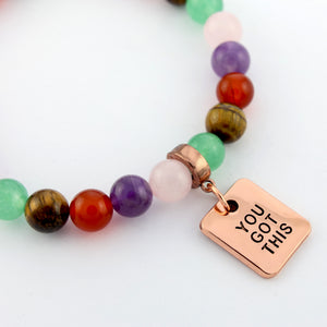Colorful beaded bracelet with a rose gold charm reading 'YOU GOT THIS' on a white background