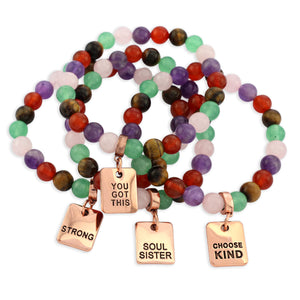 Colorful beaded bracelet with motivational charms on a white background