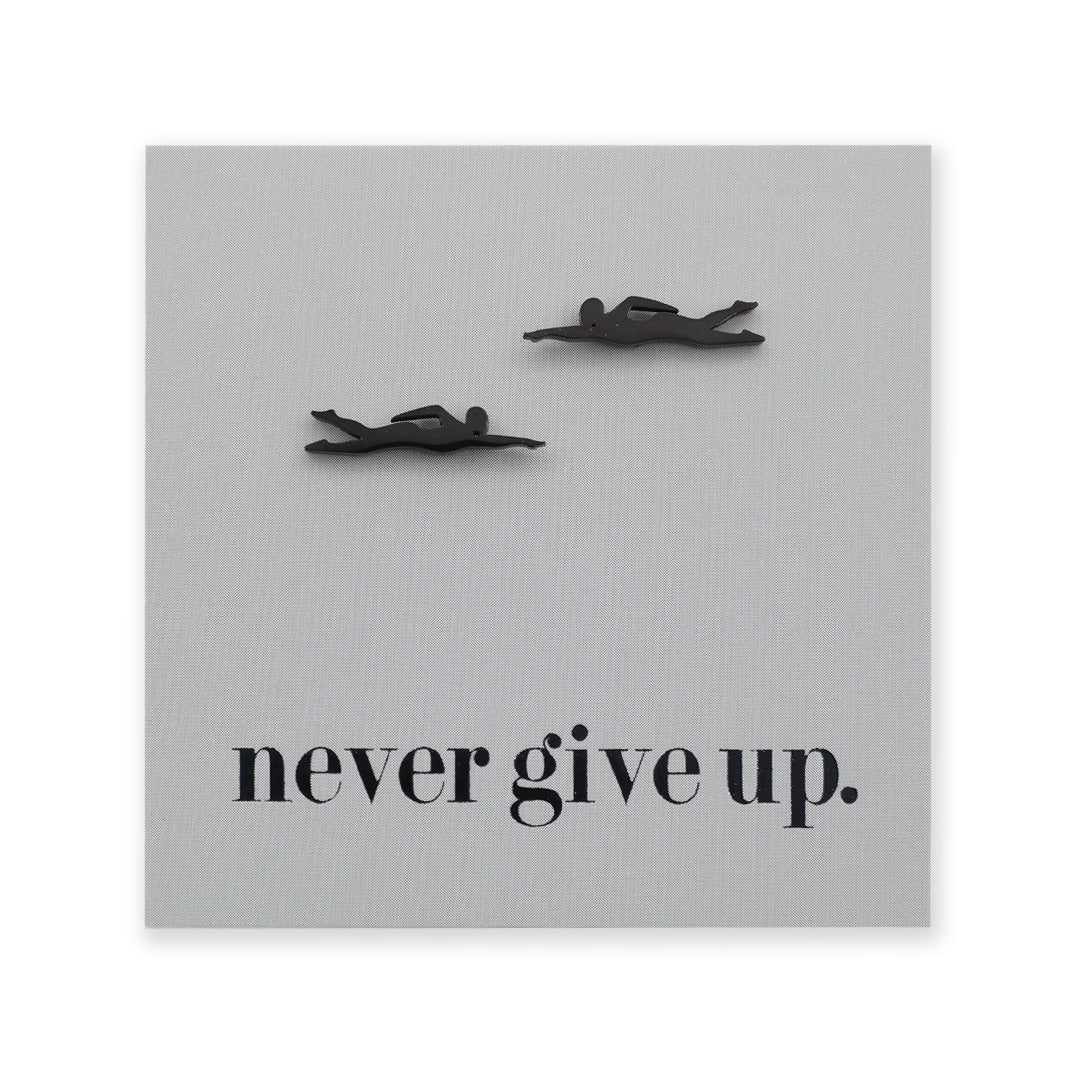 Decorative wall art with black swimming figures and 'never give up.' text on a gray background