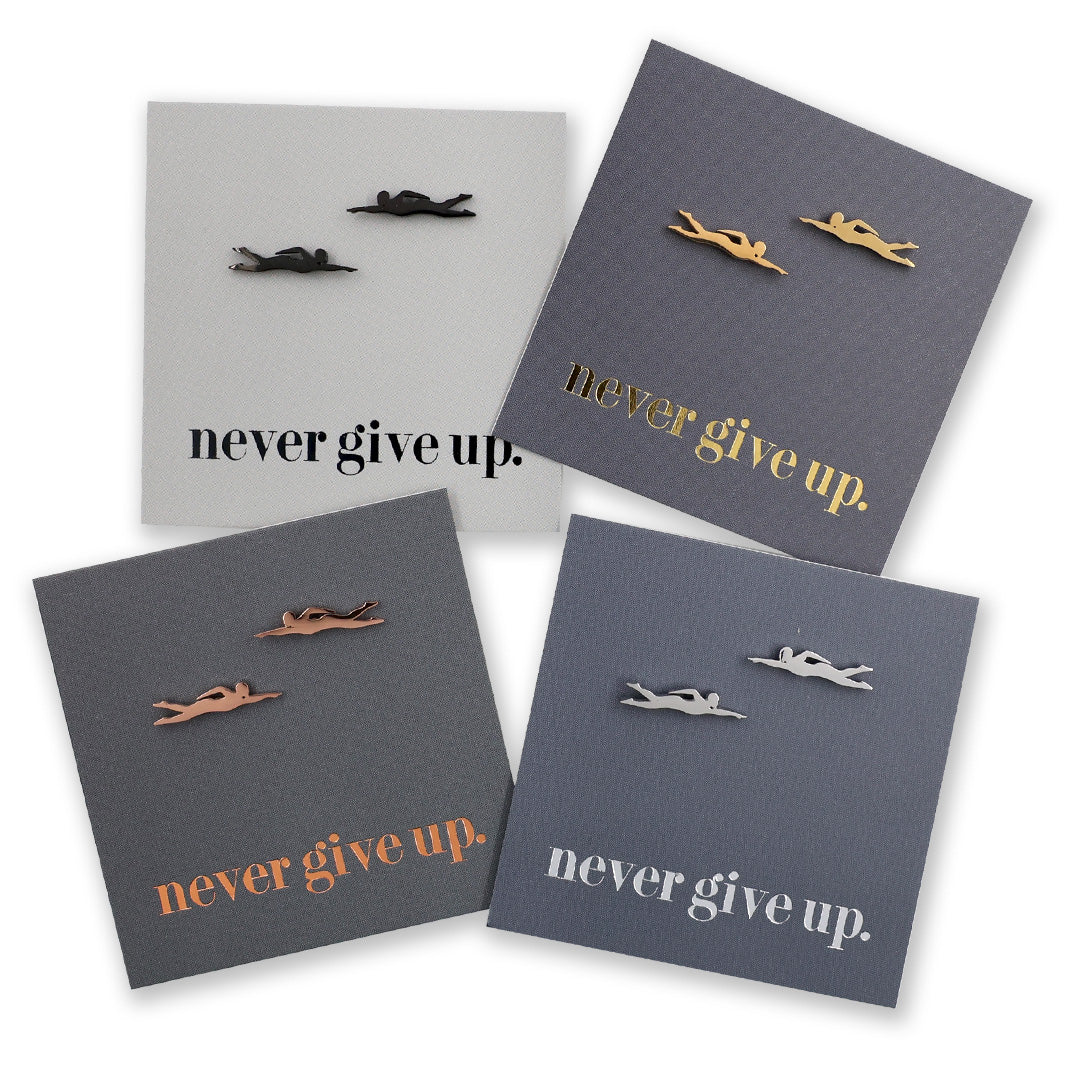 Four grey cards with motivational text 'never give up.' and small swimmer shaped figurines on a white background.