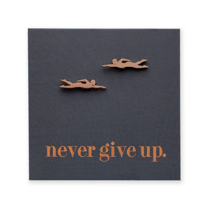 Motivational card with two swimmer figurines and 'never give up.' text on a dark blue background