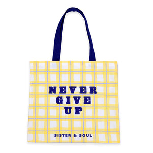 Tote bag with yellow grid pattern and blue text on a white background