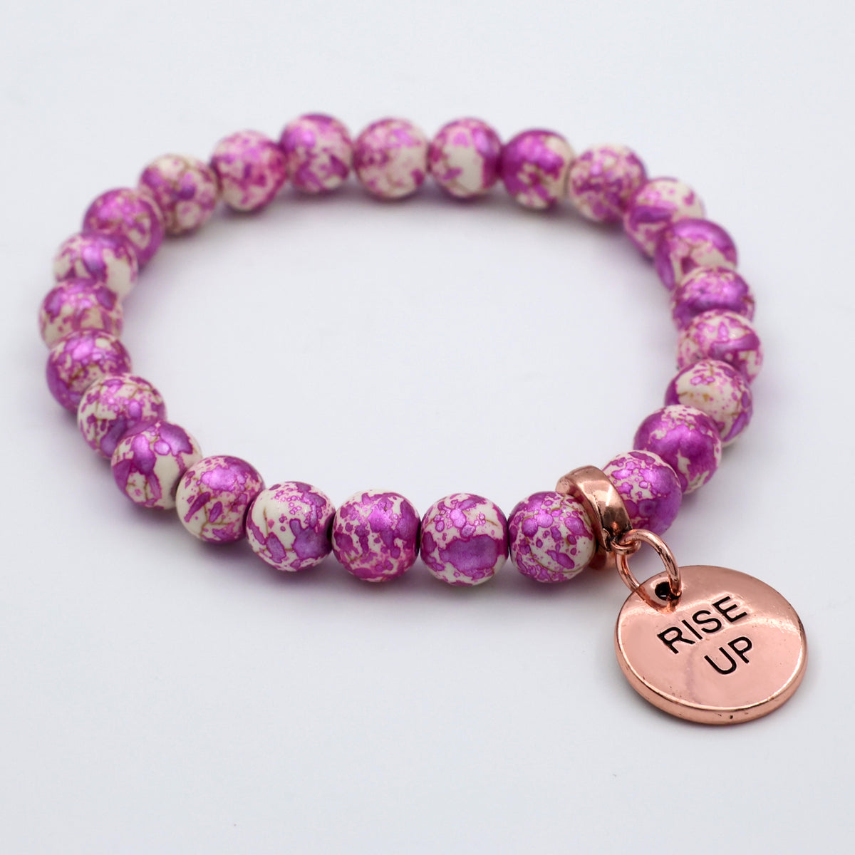 Purple beaded bracelet with a 'Rise Up' charm on a light gray background