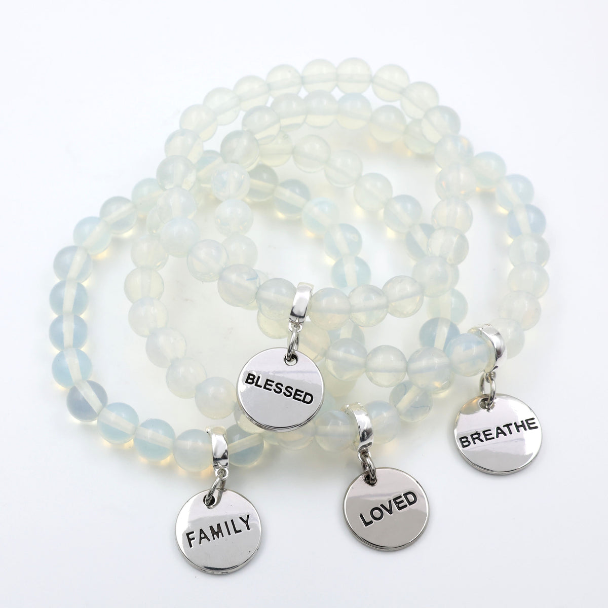 Opalite beaded bracelet with silver charms on a white background