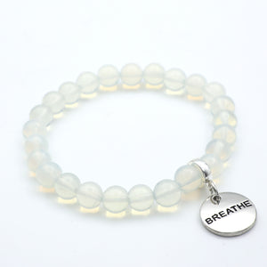 White beaded bracelet with a 'BREATHE' charm on a white background