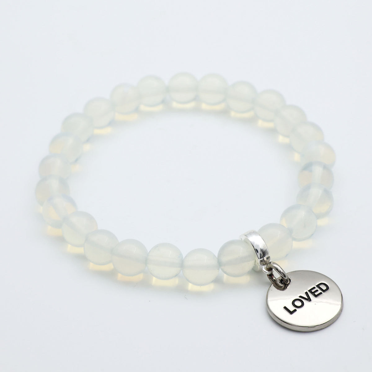 Beaded bracelet with a 'LOVED' charm on a light background