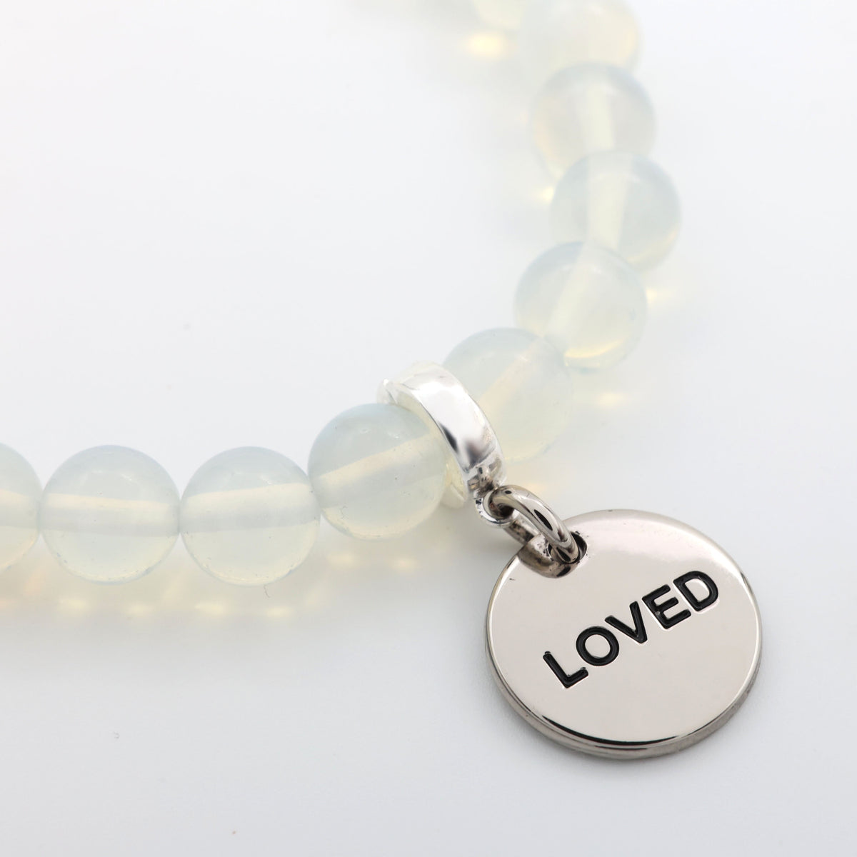Bracelet with 'LOVED' charm on a light background