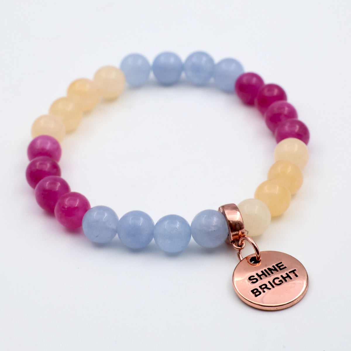 Multicolored beaded bracelet with a 'Shine Bright' charm on a white background