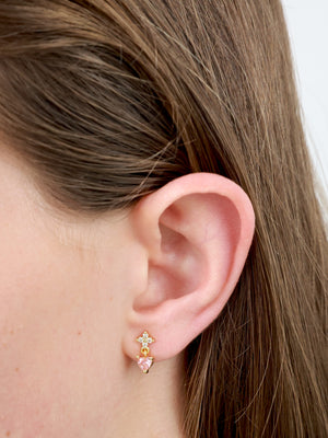 sparkling pink cubic zirconia studs pictured in a girls ear.